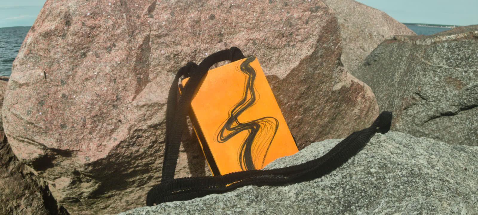 A yellow bag, made of wood and textile, with rocks